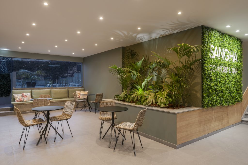 Sangha Co-work & Bar lounge with green wall and seating area, Funchal