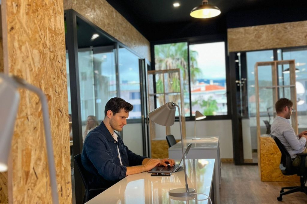 Member working at a fixed desk in the Sangha Cowork open space, Funchal